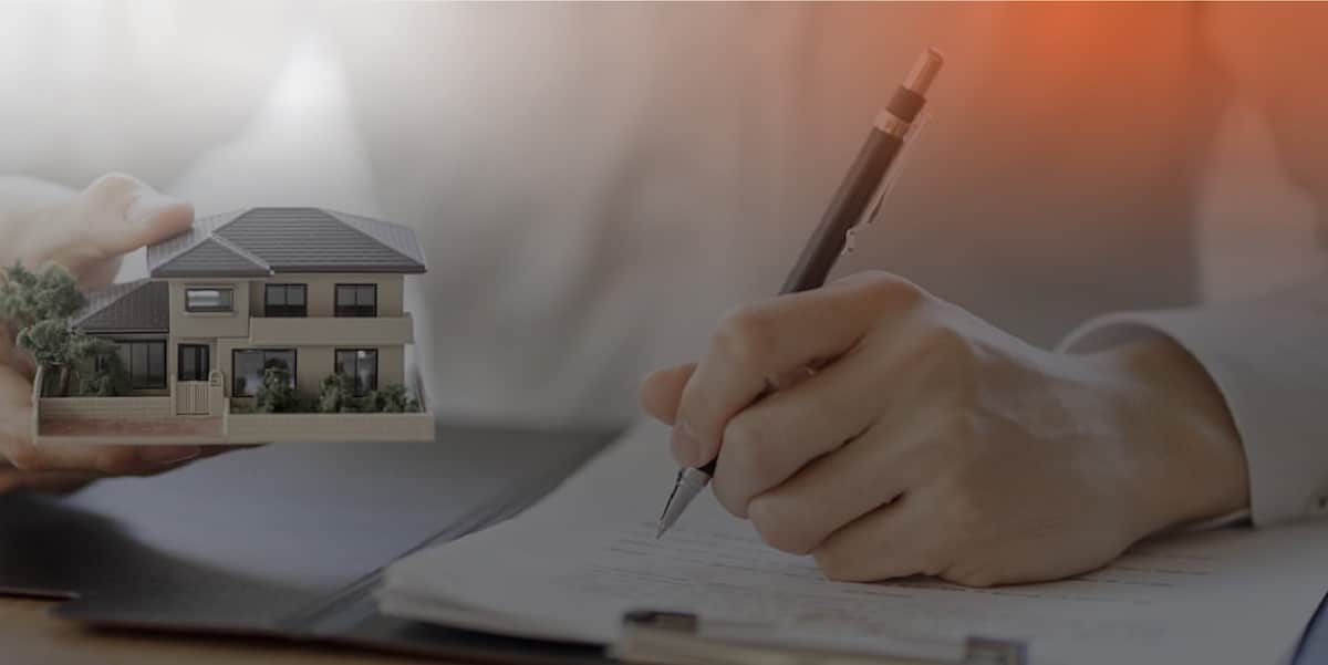 lawyer-reviewing-and-signing-an-estate-planning-contract-while-holding-a-small-model-house