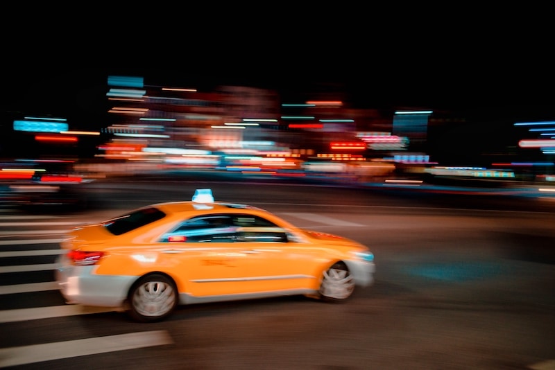 Timelapse shot of a yellow taxi in the motion at night time